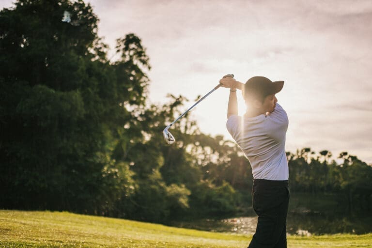 Asian Chinese golfer teeing off in golf course weekend morning — Le Domaine de Sainte-Croix à Sainte-Croix