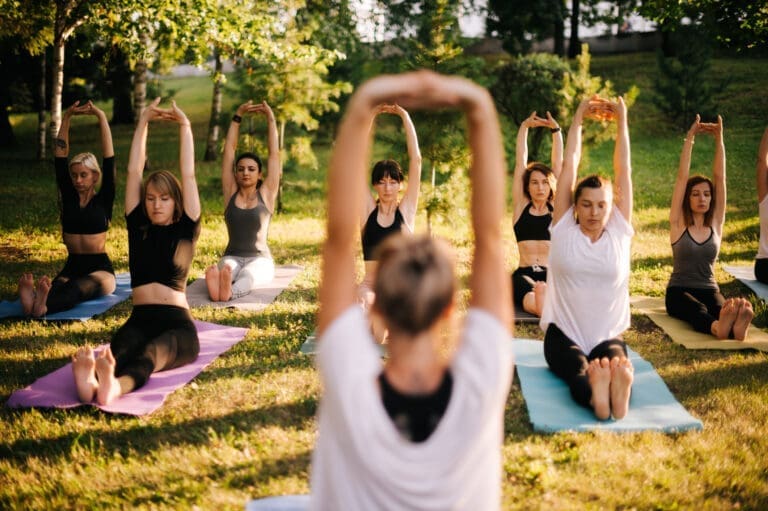 Group of women are practicing yoga and sits with hands up… — Le Domaine de Sainte-Croix à Sainte-Croix