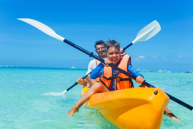 Father and son kayaking on a tropical ocean