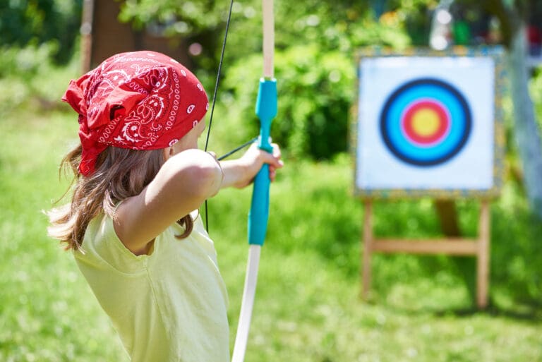 Girl with a bow aiming at a target – Archery