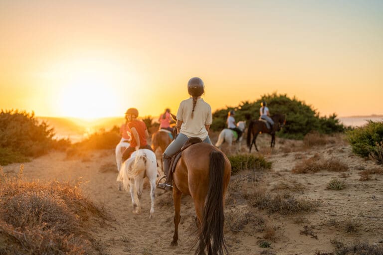 Group of young riders on horseback heading towards the beach – Horse riding