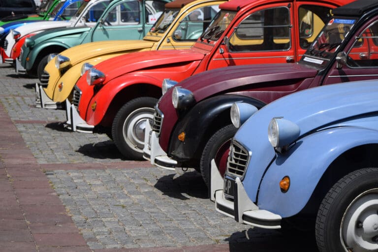 Classic Citroën 2CV cars in a row on the street – 2CV road trip